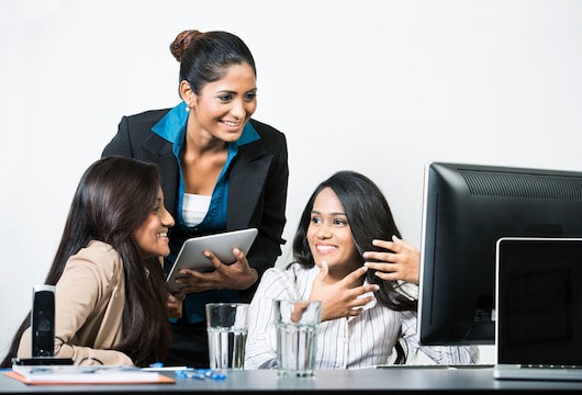 Three professional women of color working with technology women in tech